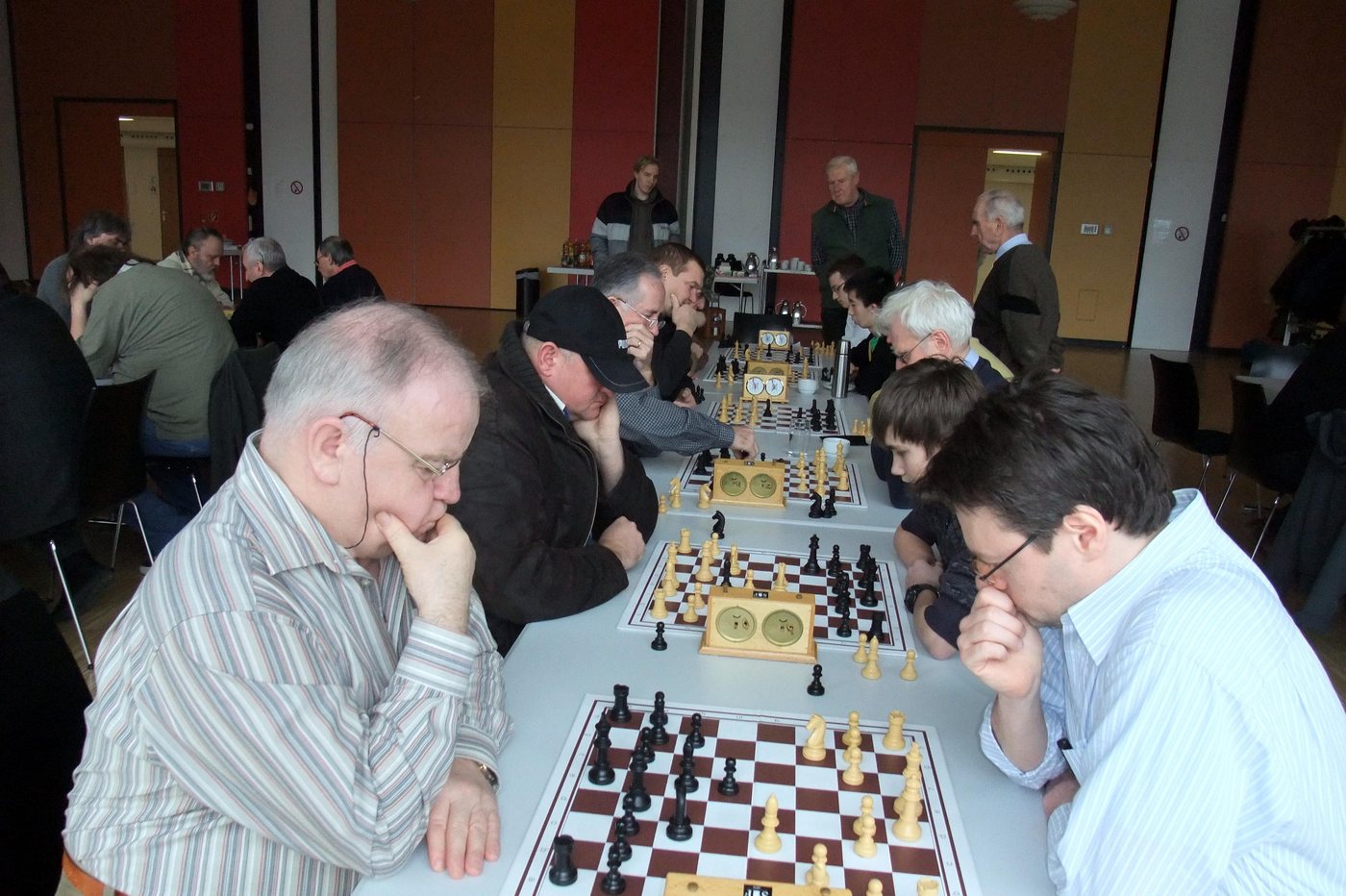 Mehrere Blitzpartien an einer langen Tischreihe